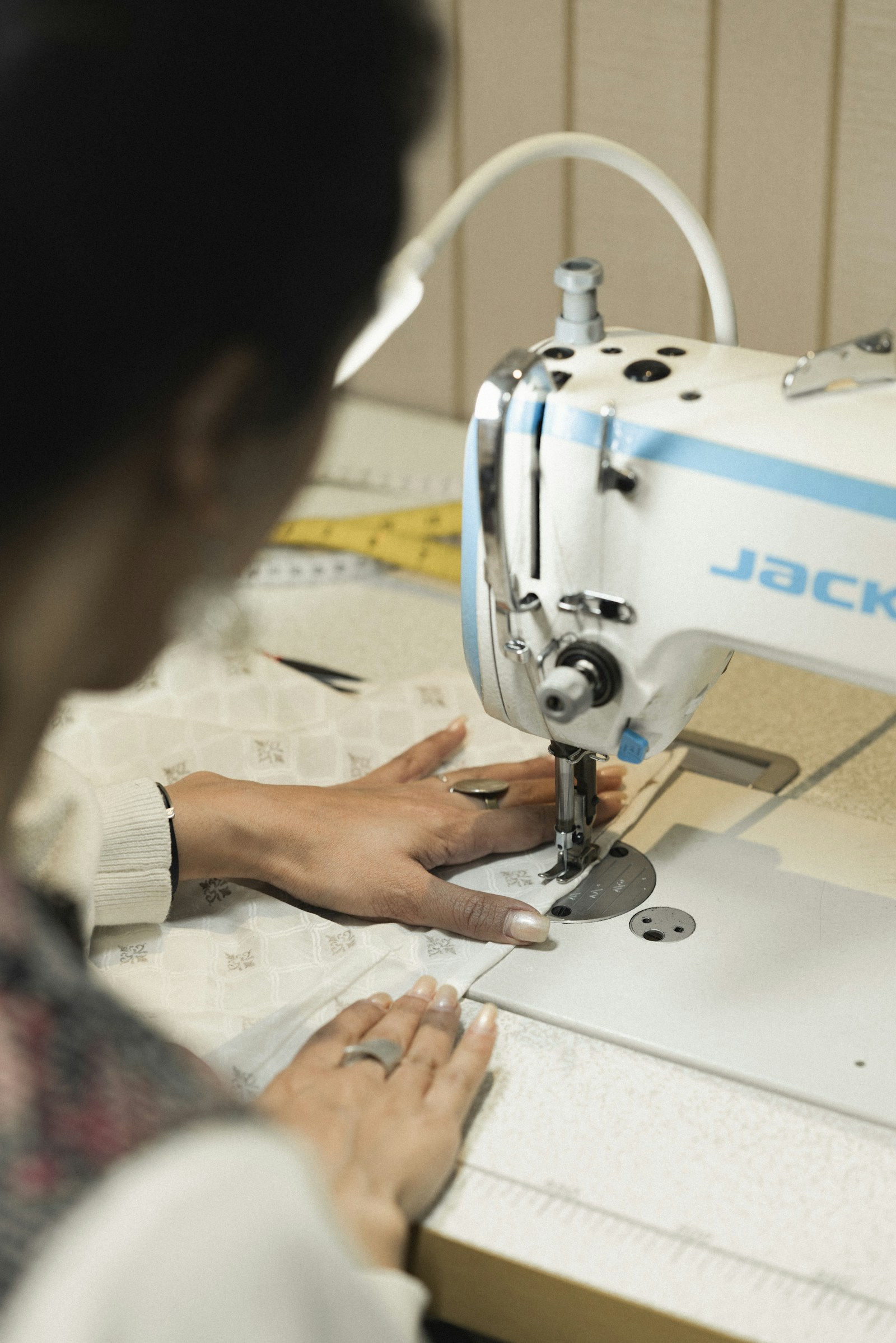 Fotografía de referencia: manos guiando una tela en una máquina de coser